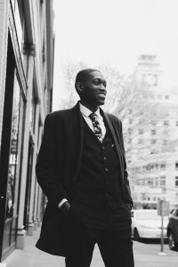 Stylish black man in suit standing on street. Photo by Maria Orlova.