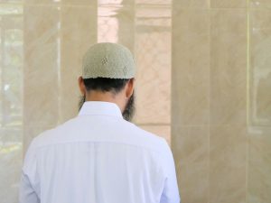 Muslim man facing a wall. Photo by Utsman Media.